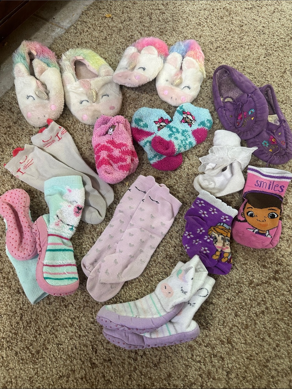 Random assortment of kids slippers and some socks